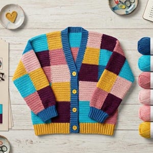 Peut inclure: Un cardigan crocheté patchwork coloré dans les tons de bleu, rose, jaune et violet. Le pull a un col en V, une fermeture boutonnée et des poignets et un ourlet côtelés. Le vêtement est présenté sur une surface en bois clair, avec du fil et des fournitures d'artisanat à proximité.