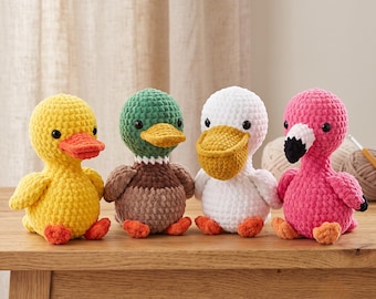 May include: Four crocheted plush toys featuring a yellow duck with an orange beak, a mallard duck with a green head and brown body, a white pelican with a yellow beak, and a pink flamingo with a black and white beak, all with black eyes.