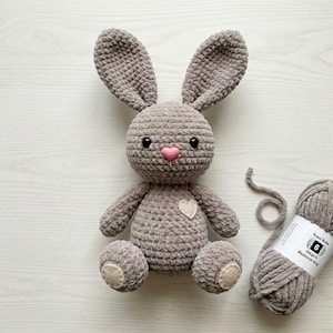 May include: A white ceramic mug with a black handle and the text "But First, Coffee" in a handwritten style. The mug is on a white surface. The mug is approximately 4 inches tall.