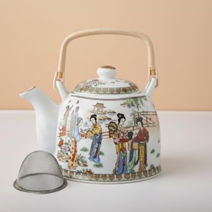 Tetera de cerámica con diseño de figura oriental y asa de ratán tejido, 900 ml.