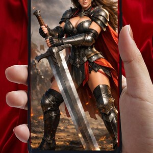 May include: A smartphone displays a digital image of a warrior woman in ornate armor, holding a large sword. The warrior wears a crown and a red cape. The background shows a battle scene.