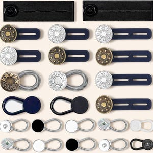 Puede incluir: Una colección de varios extensores de botones de jeans y ajustadores de cintura. Los extensores presentan botones metálicos con diseños de estrellas y flores, y algunos tienen lazos elásticos. Los colores incluyen plata, dorado, negro y azul marino.