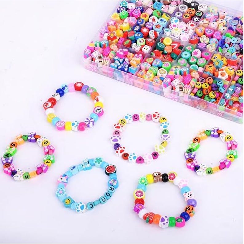 May include: A clear plastic storage container filled with assorted colorful polymer clay beads in various shapes, including letters, fruits, and animals, alongside five finished elastic bracelets made from these same multi-colored beads.