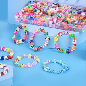 May include: A collection of colorful bracelets made from small polymer clay beads in various shapes, including fruits, letters, and geometric patterns, displayed alongside a clear plastic storage container filled with assorted loose beads.