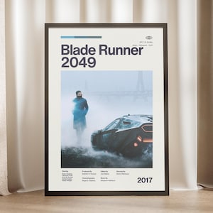 May include: A framed movie poster for "Blade Runner 2049" with a black frame. The poster features the film's title, a futuristic car, and a person in a long coat. The year "2017" is displayed at the bottom.