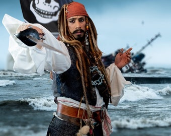 May include: A pirate costume with a red bandana, a brown leather belt, and a long, braided wig. The pirate is holding a sword and has a serious expression on their face.