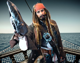 May include: A pirate costume with a brown jacket, a red bandana, and long dreadlocks. The pirate is holding a black hat and is standing on a ship's deck.