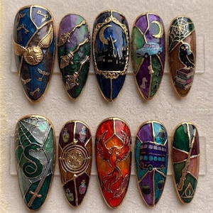 May include: A set of ten almond-shaped press-on nails featuring intricate stained-glass style designs. Each nail displays colorful enamel artwork including a golden snitch, broomsticks, a castle, a flying car, an owl, a snake, a phoenix, and a bus.