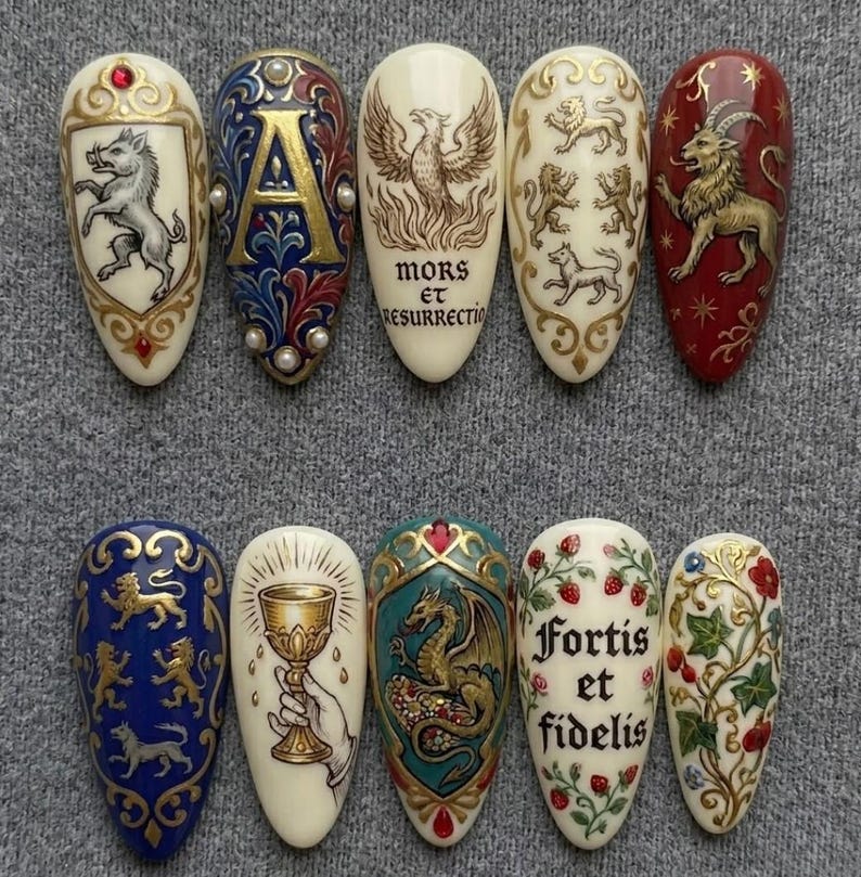 K&ouml;nnte beinhalten: Eine Sammlung von zehn aufwendig gestalteten Nagelkunstwerken. Jeder Nagel zeigt ein einzigartiges Design, darunter heraldische Symbole, ein Ph&ouml;nix und florale Muster. Die Farben umfassen Gold, Rot, Blau und Creme, mit detaillierten Kunstwerken und Text.