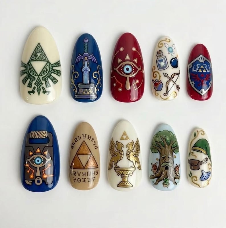 May include: A set of ten almond-shaped artificial nails, each hand-painted with designs inspired by a video game. The nails feature various colors, including blue, red, white, and gold, with detailed illustrations of symbols and characters.