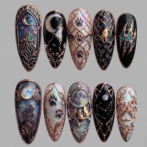 May include: A set of ten almond-shaped press-on nails featuring intricate metallic copper filigree designs. The artwork includes depictions of wolves, crescent moons, paw prints, constellations, and stained-glass patterns against black and iridescent backgrounds.