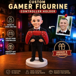 May include: A custom figurine of a person in a black suit and maroon bow tie holding a red and black video game controller. The figurine stands on a white circular base. A small photograph of a person is pinned to the right side of the image.