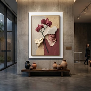 May include: A framed abstract art piece featuring a floral design with burgundy and cream tones. The artwork is displayed in a modern gallery setting, with a wooden bench and pottery in the foreground.