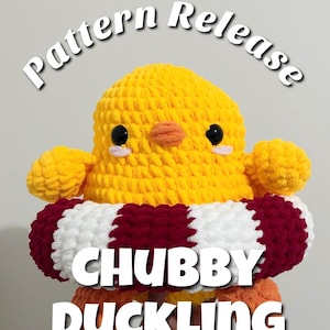 Puede incluir: Un patito de ganchillo amarillo hecho a mano con ojos negros, un pico naranja y un salvavidas rojo, blanco y burdeos. El texto "Pattern Release" y "CHUBBY DUCKLING" se muestran en la imagen. El patito es un juguete de peluche lindo.