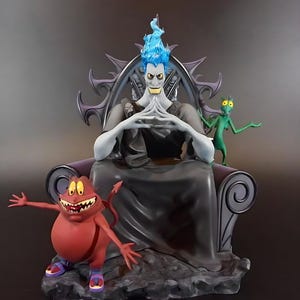May include: A detailed figurine of Hades from Disney's Hercules, seated on a throne with his two sidekicks. Hades has blue flames for hair, and is wearing a black robe. The red and green sidekicks are in a comical pose.