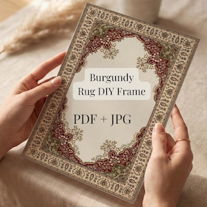 Pode incluir: Uma moldura retangular com um design de tapete bordô, com um centro creme e uma borda ornamentada. O texto "Burgundy Rug DIY Frame" e "PDF + JPG" são exibidos na moldura. A moldura é segurada por uma pessoa.