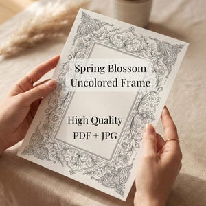 May include: A rectangular white paper sheet featuring a black line art floral border design. The text on the paper reads: Spring Blossom Uncolored Frame, High Quality, PDF + JPG. The design includes intricate botanical patterns and roses.