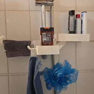 May include: A white shower organizer with multiple shelves and hooks. It holds a dark brown bottle, several other bottles, a gray towel, and a blue loofah. The organizer is mounted on a shower rod.