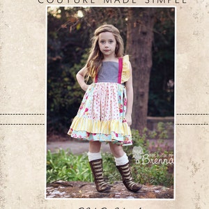 Puede incluir: Una niña pequeña lleva un vestido de varios niveles de colores con un corpiño gris y volantes amarillos, rosas y blancos. Lleva botas marrones y está de pie sobre una roca. La imagen es de CKC Patterns, una empresa que crea patrones de ropa de alta costura.