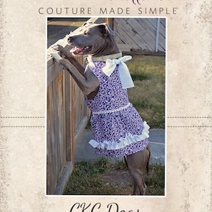 May include: A gray dog wearing a purple and white floral dress with a white bow. The dog is standing on its hind legs and leaning against a wooden fence. The text "CKC Patterns Couture Made Simple" is at the top of the image and the text "CKC Dogs" is at the bottom of the image.