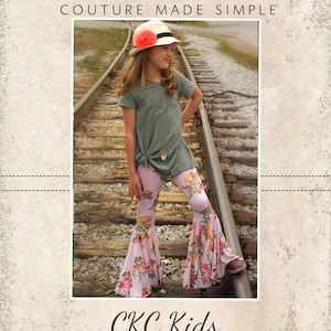 May include: A young person wearing a green shirt, a pink floral print bell bottom pants, and a straw hat with a pink flower on top. The person is standing on railroad tracks. The image includes the text "CKC Patterns Couture Made Simple" and "CKC Kids".