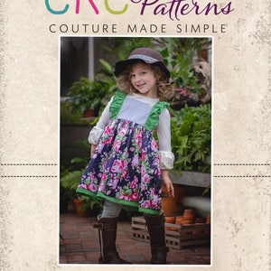 May include: A girl in a floral dress with green trim and ruffled straps, brown boots, and a hat. The image features the text "CKC Patterns" and "CKC Kids". The dress has a navy blue background with pink flowers.