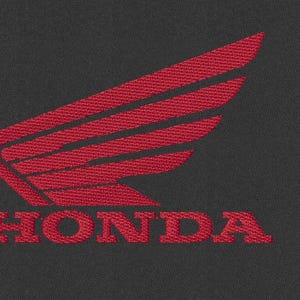 Peut inclure: Logo Honda rouge brodé sur fond gris foncé. Le logo présente un design d'aile stylisé au-dessus du nom de la marque. Le texte et l'aile sont rendus dans un style texturé et cousu, créant un look classique.