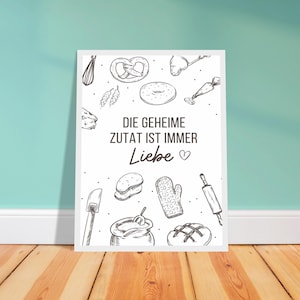 Peut inclure: Une affiche encadrée avec une bordure blanche, présentant des dessins au trait d'ustensiles de boulangerie et de produits de boulangerie. Le texte "DIE GEHEIME ZUTAT IST IMMER Liebe" est centré. L'affiche est affichée sur un sol en bois contre un mur turquoise.