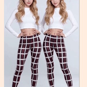 May include: A long-sleeved white crop top paired with high-waisted leggings featuring a dark red and black grid pattern over a white background. The outfit is completed with white pointed-toe high heels, creating a coordinated ensemble.