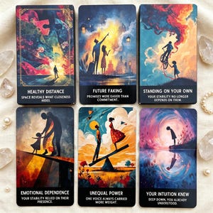 May include: Six tarot cards with colorful illustrations and text. The cards feature images of people and abstract art with phrases like "Healthy Distance" and "Future Faking." The cards are arranged on a cream-colored surface with pearls and crystals.