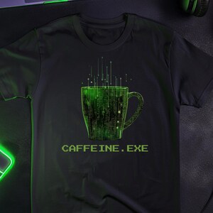 May include: A black short-sleeve t-shirt featuring a graphic of a coffee mug composed of green digital code and binary-style characters. Above the mug are vertical green lines, and below the mug is the text CAFFEINE.EXE in green.