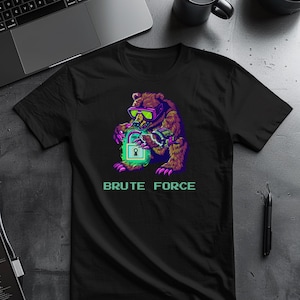 May include: Black t-shirt featuring a colorful graphic of a bear wearing goggles and holding a glowing padlock. The text "BRUTE FORCE" is printed below the bear in a pixelated font. The bear is brown, purple, and green.