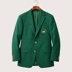 May include: A dark green blazer with gold-coloured buttons and a golf course emblem. The jacket is displayed on a wooden hanger. The blazer has two front pockets and three buttons on each cuff.
