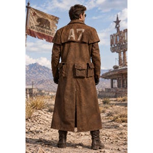 May include: A long, brown, weathered-texture duster coat featuring a wide shoulder cape, two large utility pockets on the back, and the text A7 printed in large, light-colored block letters across the upper back panel, paired with dark boots.