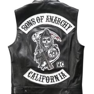May include: Black leather vest with the "Sons of Anarchy" logo on the back. The logo features a grim reaper with a scythe and a gun, along with the words "Sons of Anarchy" and "California".