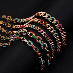 May include: Gold-toned chain bracelets with colorful enamel links in various shades of pink, blue, green, red, and white. The bracelets are displayed on a black surface, showcasing their vibrant colors and design.