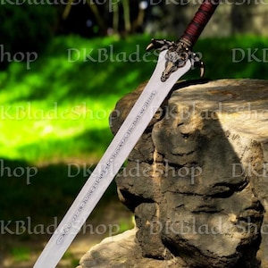 K&ouml;nnte beinhalten: Ein detailliertes Fantasy-Schwert mit einer silbernen Klinge und einem verzierten Bronzegriff. Der Griff ist mit einem dunkelroten Material umwickelt. Die Klinge hat ge&auml;tzten Text. Das Schwert liegt auf einem Felsen. Das Design deutet auf eine Fantasy-Waffe hin.