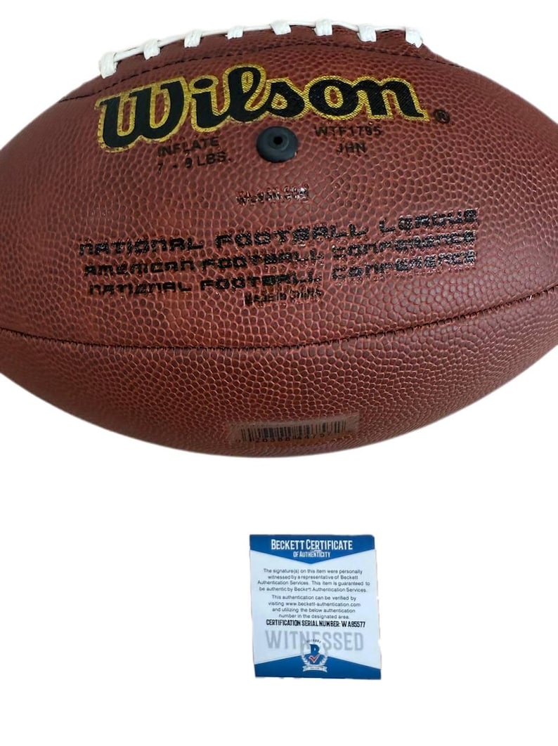 May include: A brown leather Wilson NFL football with white stitching. The football is inflated to 7-9 lbs. The text "Wilson" and "NATIONAL FOOTBALL LEAGUE" are visible. A Beckett Certificate of Authenticity is included.