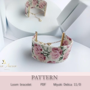 May include: Two loom bracelets with a floral design in pink, white, and green. The bracelets have gold-coloured accents and are displayed on a white surface. The word "PATTERN" is visible.