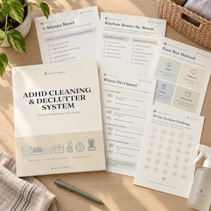 May include: A printed ADHD Cleaning & Declutter System guide with multiple instructional sheets, including a 5-Minute Reset, Kitchen Room-by-Room, Four-Box Method, Where Do I Start, and a 30-Day Declutter Challenge, accompanied by a green pen.