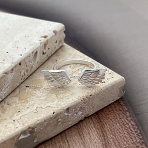 May include: A handmade wooden sign with the text "Welcome to our home" in a handwritten style. The sign is painted white with a dark stained frame. A small, decorative heart is in the bottom right corner.