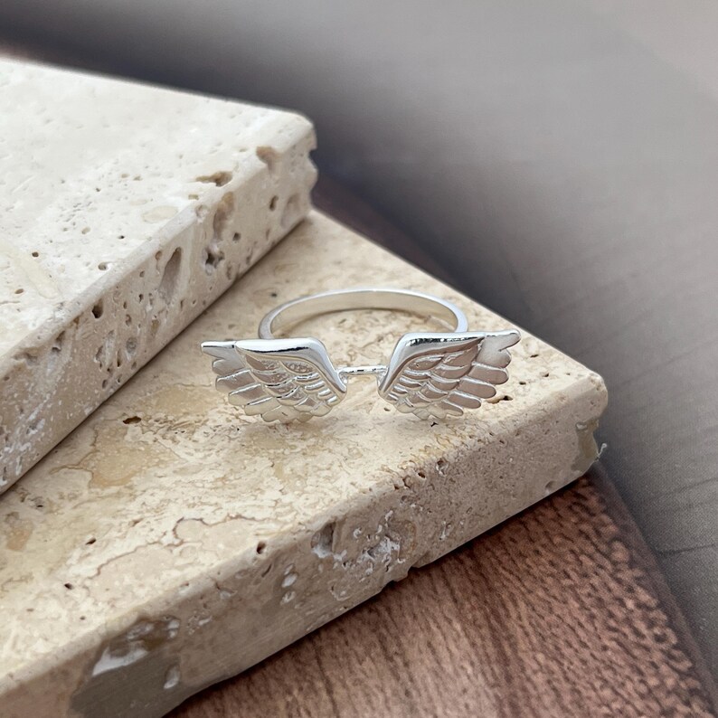 May include: A handmade wooden sign with the text "Welcome to our home" in a handwritten style. The sign is painted white with a dark stained frame. A small, decorative heart is in the bottom right corner.