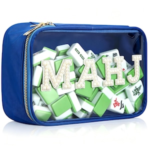 Puede incluir: Un estuche rectangular azul con cremallera y panel frontal transparente lleno de fichas de mahjong blancas y verdes. Las letras M, A, H y J están fijadas en el panel transparente, decoradas con perlas blancas y brillantes de imitación.