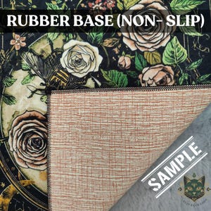 Puede incluir: Una alfombra floral con fondo negro y base de goma. La alfombra presenta rosas en tonos crema y melocot&oacute;n, con hojas verdes. El texto "RUBBER BASE (NON-SLIP)" est&aacute; en la parte superior. La parte inferior de la alfombra es de color marr&oacute;n claro.