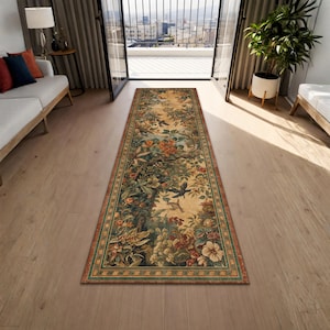 Puede incluir: Una alfombra rectangular larga con un diseño detallado de flores y pájaros. La alfombra presenta un fondo color crema con un borde verde y marrón. El diseño incluye varias flores, pájaros y follaje.