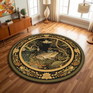 Puede incluir: Alfombra redonda con una detallada ilustración de una rana en un entorno natural. La alfombra tiene un fondo negro, un borde dorado y detalles florales. La rana se representa en tonos verdes y marrones.