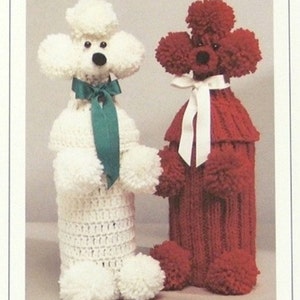 May include: Two crocheted poodle bottle covers, one white with a green bow and one red with a white bow.