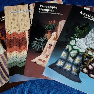 May include: Four softcover crochet pattern booklets titled Mile-A-Minute, Double-Quick, Pineapple Sampler, and Amazing Star Afghans. Each cover features color photographs of crocheted afghans with various geometric and floral patterns.