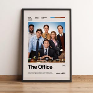 Könnte beinhalten: Ein gerahmtes Poster für die Fernsehserie "The Office" mit einem Cast-Foto. Das Poster hat einen schwarzen Rahmen und zeigt den Titel der Serie in großen weißen Buchstaben. Das Poster enthält auch das Jahr 2005.