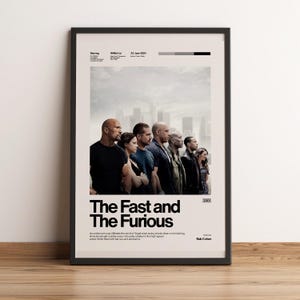 Könnte beinhalten: Ein gerahmtes Filmplakat für The Fast and the Furious mit einem schwarz-weißen Gruppenfoto der Besetzung, dem Filmtitel in fetter schwarzer Schrift, dem Datum 22. Juni 2001 und einer kurzen Inhaltsangabe auf cremefarbenem Hintergrund.